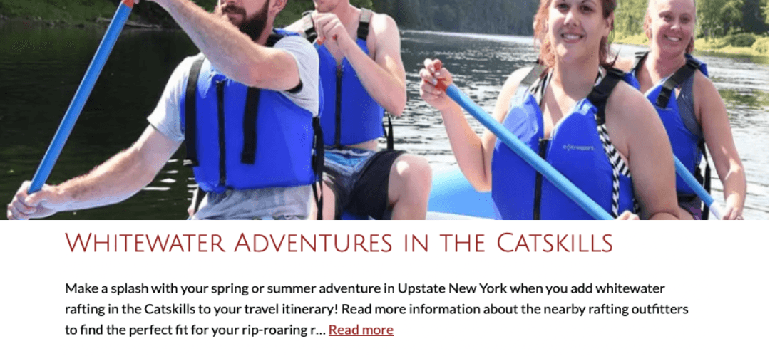 Four people in blue life jackets paddle on a river during a whitewater rafting adventure.