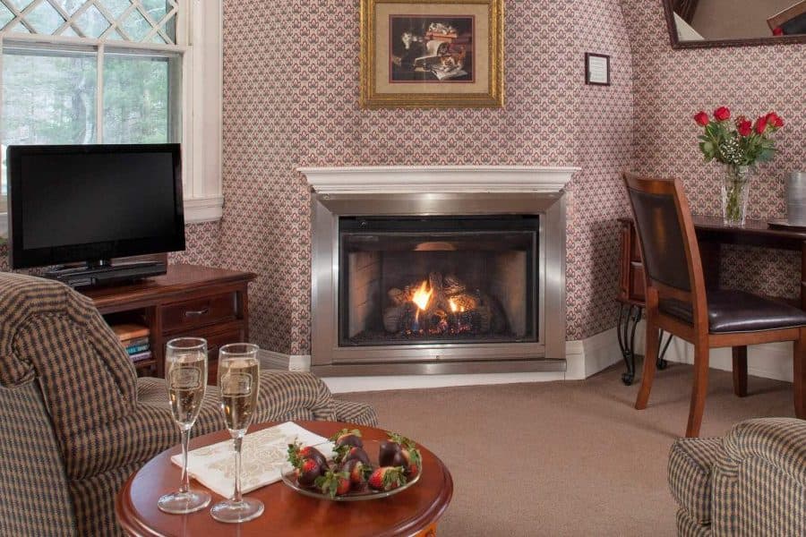 Cozy living space with a fireplace, television, and refreshments on a table.