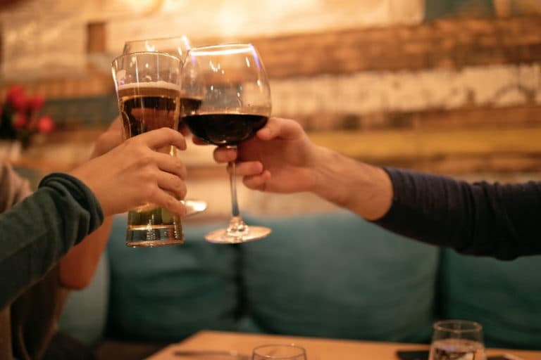 Cheers with drinks in a cozy setting.