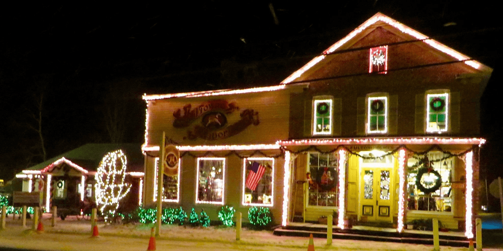 A brightly lit building adorned with holiday decorations at night.