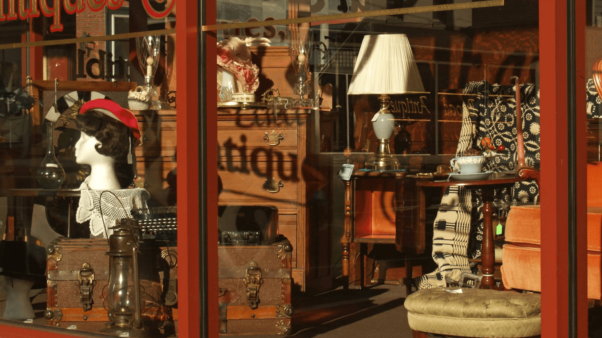 A display window showcasing antiques and collectibles, featuring various vintage items and decor. A display window showcasing antiques and collectibles, featuring various vintage items and decor.